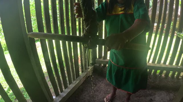 Person Stirring Traditional Food Over Fire in Ecuador Amazon House, Wooden Wall Interior, Rural Cooking Practice and Local Jungle Culture Scene