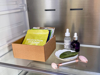 Skincare products and sheet masks stored in a refrigerator for a cooling beauty routine. Aesthetic flat lay and composition of cosmetic products, face sheet masks, serum bottles, jade roller © Jekaterina