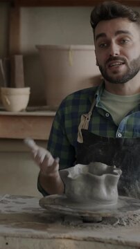 Creative vlogger recording tutorial about pottery talking and shaping clay using smartphone camera in workshop. Vlogging and small business concept.