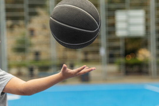 Basketball player throwing ball on outdoor court