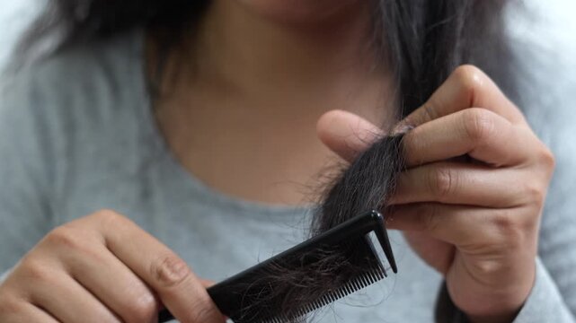 woman sticking brushing her hair falling out and have many hair loss on the comb. problem of Damaged and frizzy. Healthcare and medical concept.