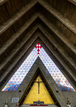 View of the altar and crucifix beneath stained-glass triangles inside the Cathedral of Our Lady of Fatima, Benguela Province, Benguela, Angola