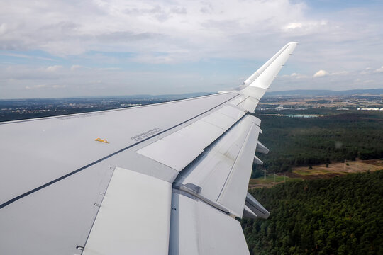 Airplane Wing With Extended Flaps During landing Roll Over Runway At Airport