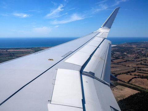 Airplane Wing With Extended Flaps During landing Roll Over Runway At Airport