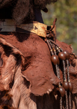 Close-up of a woman's shoulder wearing a carved bone choker and a leather cape with beaded tassels, Cunene Province, Oncocua, Angola