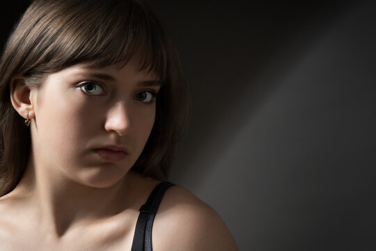 Portrait of a beautiful young teenage girl posing on dark background