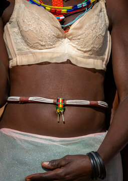 Close-up of a woman's torso wearing a lace bra beneath colorful beaded necklaces with key pendants, Cunene Province, Cahama, Angola