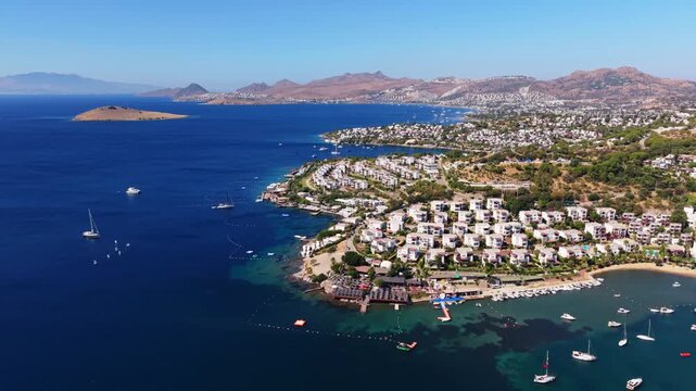 Drone flying overhead luxury yachts and villas on the waters edge of Bodrum