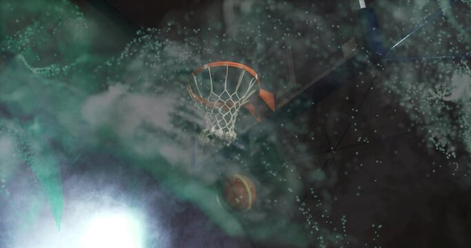 Swooping basketball passing upward through rim and net in dark studio, with spotlight and smoke