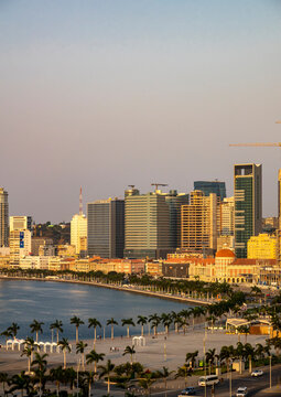 Hazy sky stretches above the skyline and palm-lined waterfront of Luanda Bay, Luanda Province, Luanda, Angola