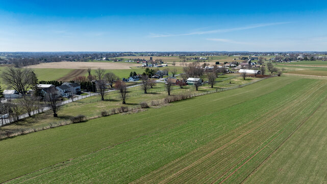 Wide View of Farmland and Small Houses Near a Town in Rural America During Daylight