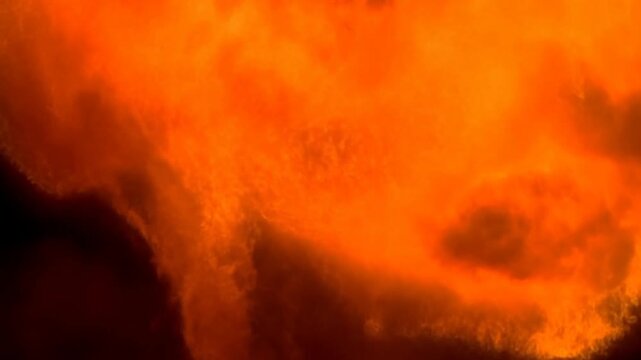 Bright Orange Fireball Glowing Against Black Background With Dark Central Opening
