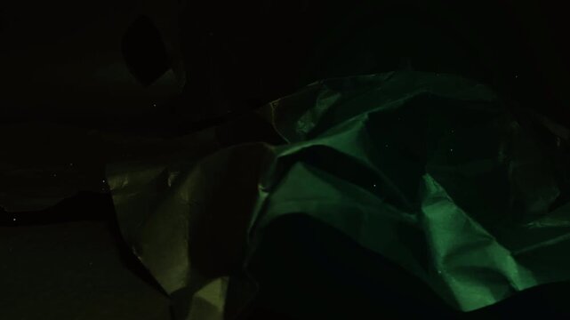 Abstract dark green satin fabric waves in soft light.