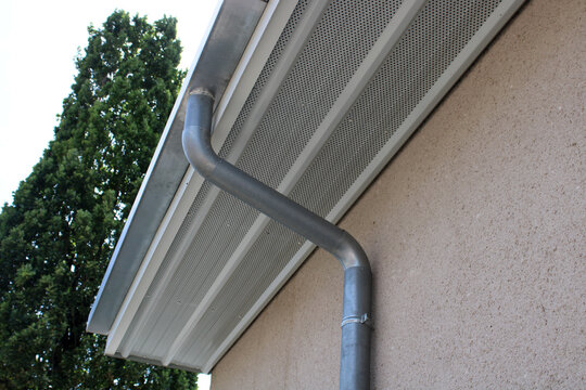 Panneau de soffite perfor&eacute; en aluminium blanc assurant la ventilation sous l&rsquo;avant-toit, avec goutti&egrave;re et descente en zinc