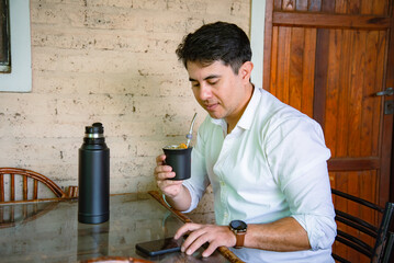 Hombre relajado tomando mate junto a su teléfono móvil © Daniel