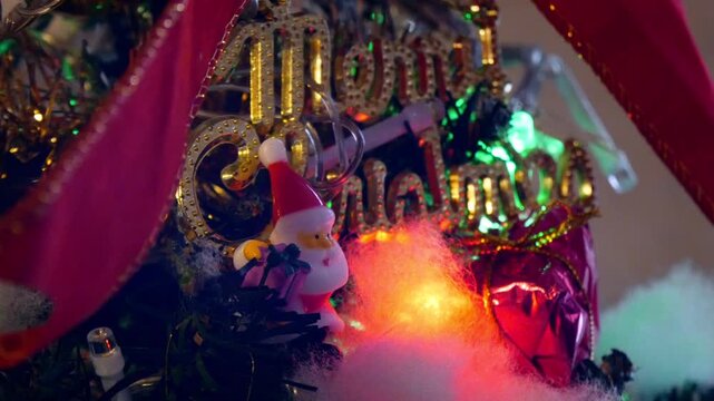 ライトが点滅するクリスマスツリー　メリークリスマスの文字とサンタクロースのオーナメント　