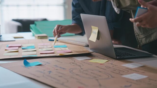 Business hands creating project mind map with colorful sticky notes