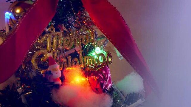 ライトが点滅するクリスマスツリー　メリークリスマスの文字とサンタクロースのオーナメント