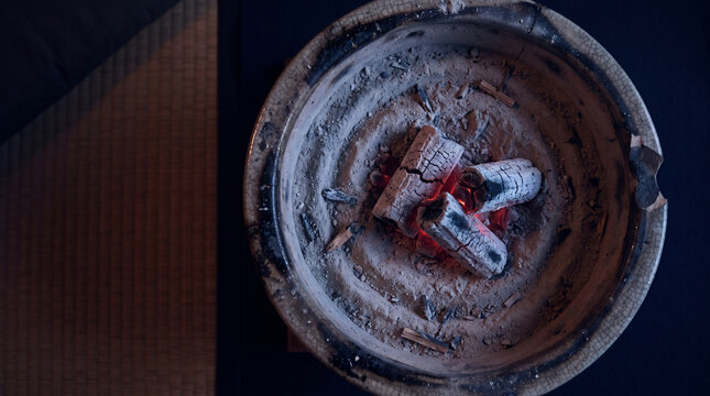 Overhead view of glowing charcoal in a Japanese brazier at night