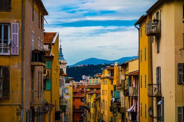 Fototapeta premium Colorful buildings on a narrow street with mountains in the background