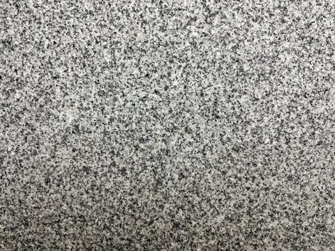 Close-up of rough gray granite stone surface with natural speckled texture.