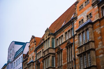 Obraz premium Ornate brick buildings with tiled roofs against a pale sky