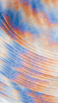 Rusted metal surface with colorful oxidation and curved lines texture