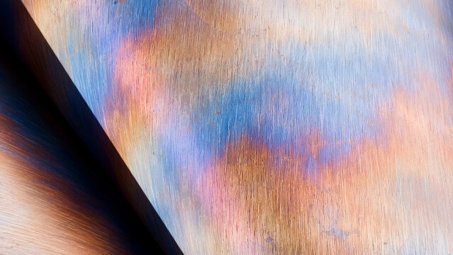 Close-up view of metal surface with colorful oxidation and rust