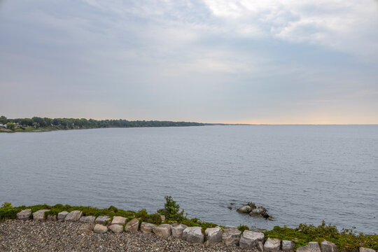 Breathtaking view of Kingsville, Ontario shoreline from the Pelee Island ferry, showcasing serene waters and a distant horizon under a cloudy sky.