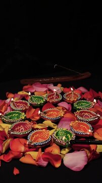 Hand Lighting Colorful Diya Lamps for Diwali Celebration
