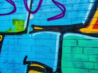 Bright graffiti art on blue brick wall © Novanture