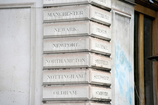 Historic Stone Building Facade with Engraved English Town Names