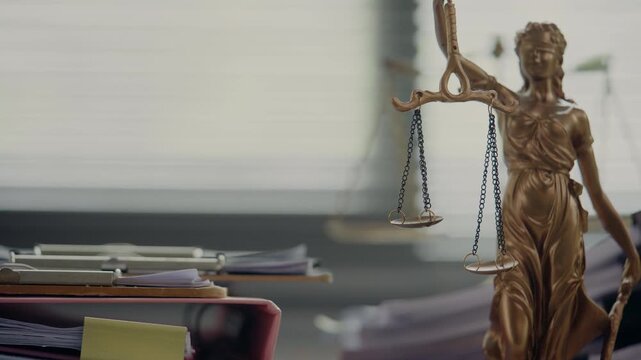 cales of Justice in Front of Stacked Legal Documents in Law Office