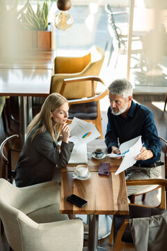 Business colleagues discussing financial reports at cafe