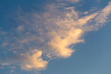 Obraz premium Soft fluffy clouds drifting across a clear blue sky, airy cloudscape, atmospheric texture, peaceful mood.