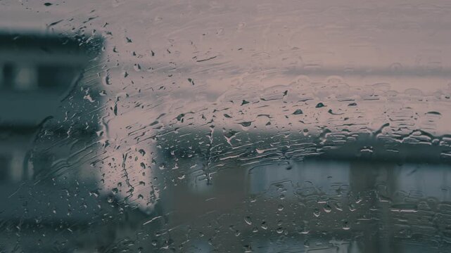 City street view with raindrops on a car window in nostalgic negative film style