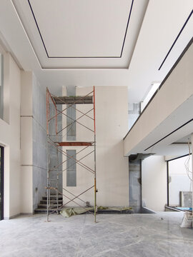 Steel scaffolding standing inside modern high ceiling home atrium under renovation, Jakarta August 28 2026
