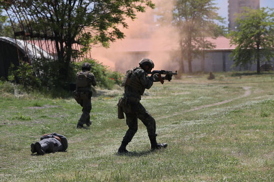Armed special forces soldiers in camouflage tactical gear during a tactical combat exercise or combat operation