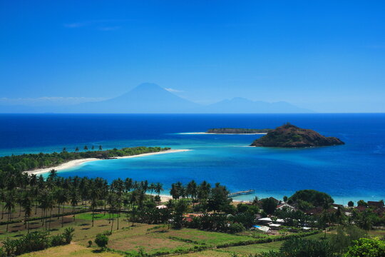 Panoramic tropical coastline with turquoise sea, small islands and coconut palms in Sekotong, West Lombok, West Nusa Tenggara, Indonesia.
