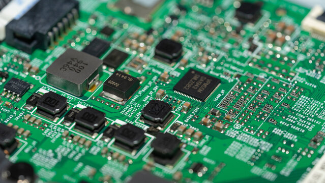 Angled macro view of surface mount electronic components on green circuit board