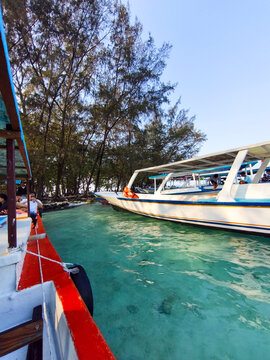 Kepulauan Seribu, Indonesia  September 05, 2026 Rows of passenger boats docked near a clear water island shore surrounded by trees.
