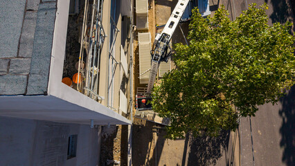 Aerial detail of a concrete building facade with a crane boom © Thomas