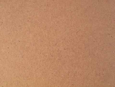 Brown board surface texture closeup background. Hardboard, mdf, chipboard, or recycled cardboard material background concept for carpentry, construction, craft, packaging, and design background