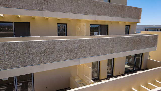 Beige apartment balconies with concrete parapets seen from above