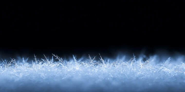 Macro of ice crystals and delicate frost needles on dark background. Winter snowflake texture with empty black space. Christmas border. Cold weather concept
