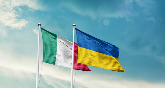 Italy Ukraine friendship flags are waving in the sky. Two country flag for agreement or deal. Italy Ukraine national flag for commitment.