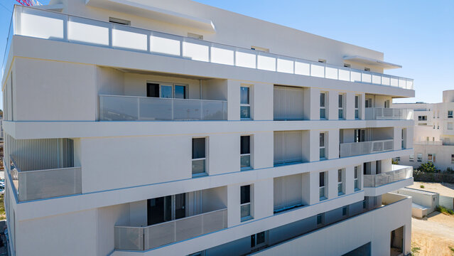 White apartment building with curved balcony parapets