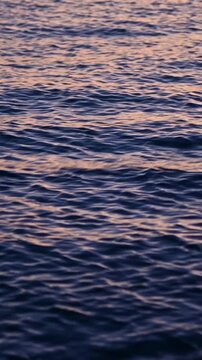 Rippling water surface with warm reflections at sunset