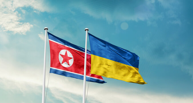 North Korea Ukraine friendship flags are waving in the sky. Two country flag for agreement or deal. Korea Ukraine national flag for commitment.