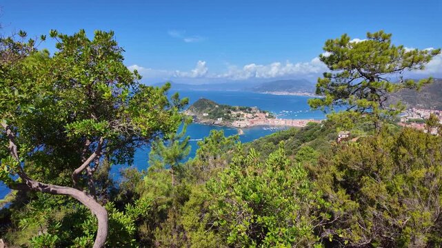Pine trees framing coastal town and blue sea view. Sestri Levante, Italy